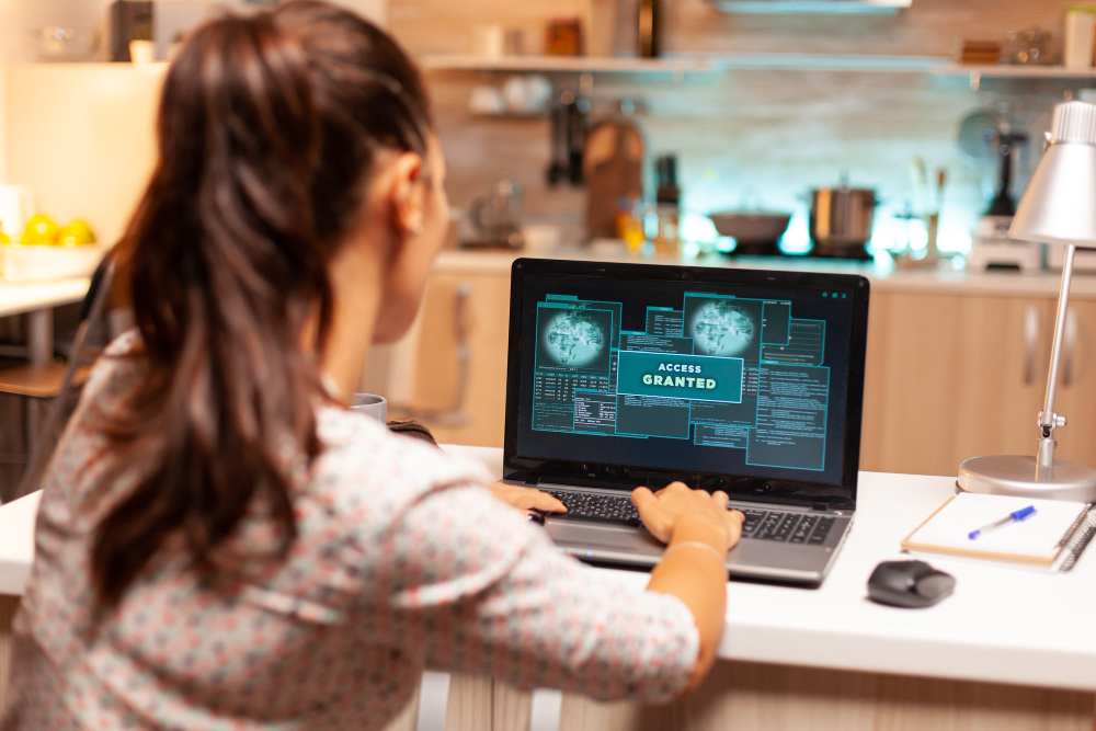woman in front of a computer that prompts access granted