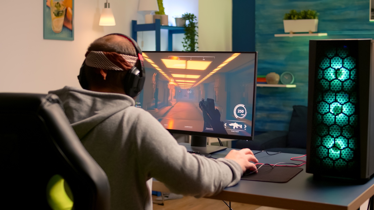 Person wearing headphones working at a desk in a home office.