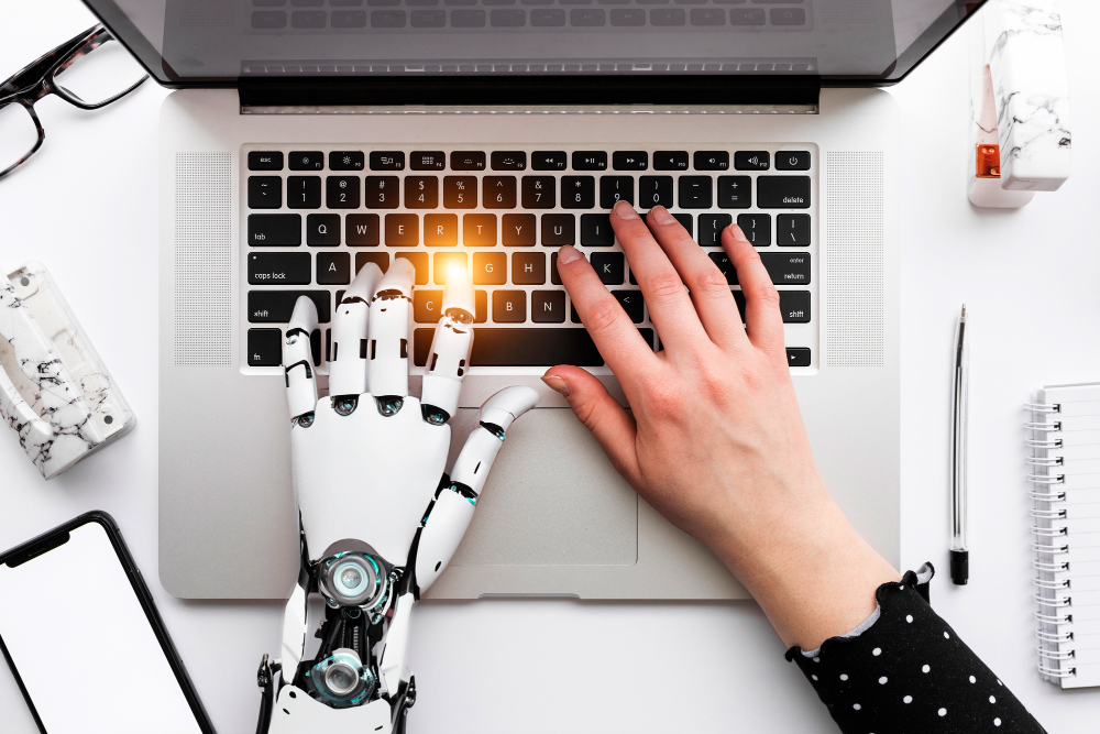 laptop with robot and human hand